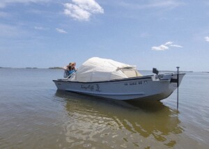 Boat with tent on calm water.